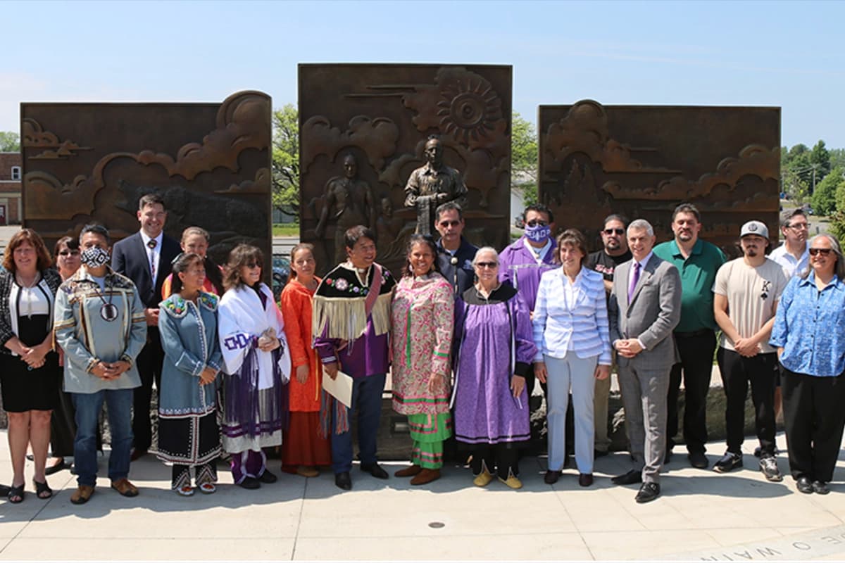 Photo of a group in front of bronze scuplture